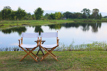 Couple of wooden camp foldable chair at terrace in front of camping tent. Place for relax and take a break and spend your vacation.