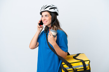 Young delivery woman with thermal backpack isolated on white background holding coffee to take away and a mobile