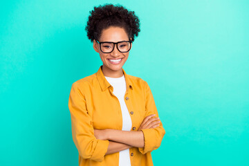 Portrait of attractive cheerful content girl folded arms isolated over vibrant teal turquoise color...