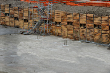 construction pit where underground garages are being built. wooden excavation sheeting and securing...