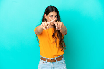 Young caucasian woman isolated on blue background making stop gesture with her hand to stop an act