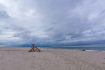 Seascape. Wooden hut on a sandy beach by the Baltic Sea on a windy autumn day - 472030872