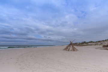 Seascape. Wooden hut on a sandy beach by the Baltic Sea on a windy autumn day - 472030889