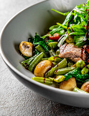 Roastbeef salad with green beans and mushroom in a bowl 