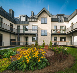 Yard of luxury residential townhouse. Flowers in garden.