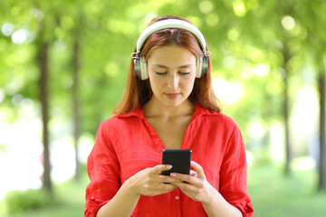 Front view of a woman in red listening to music in a park