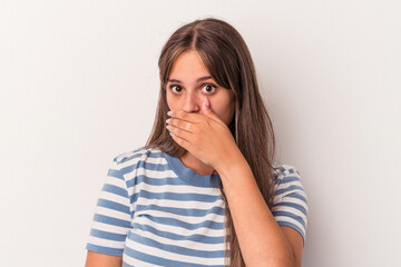 Young caucasian woman isolated on white background covering mouth with hands looking worried.