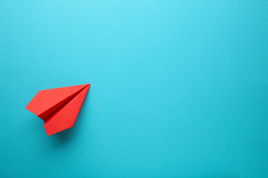 Red paper airplane on a blue background