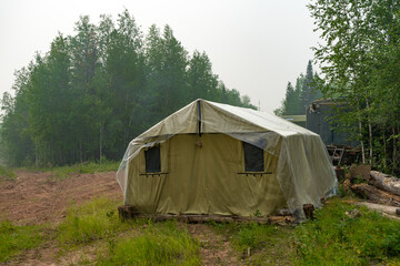 Fototapeta na wymiar Military tent in the field. field camp in nature. large green tarpaulin tent. Army camp.