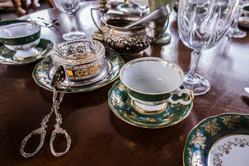 Table setting. In the foreground is a silver tongs