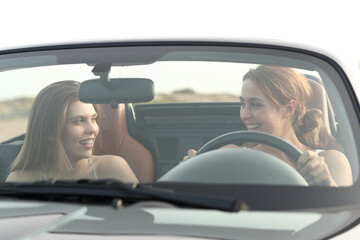 Two happy friends in a convertible car