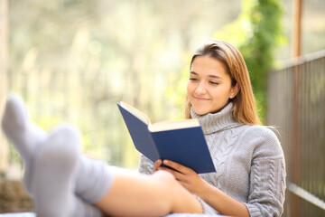 Fototapeta na wymiar Woman relaxing reading a book in a terrace