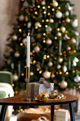 Christmas and New Year background - gift boxes, presents, candles, against the background of bokeh lights of a decorated Christmas tree. Soft selective focus.