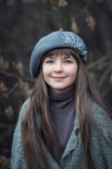 A beautiful girl with long hair in a gray beret.
