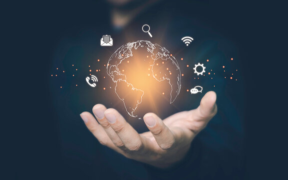 Hand holding virtual cloud computing with world and technology item such as upload download.