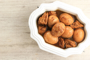 Top View Semur Tahu Telor is Boiled Eggs and Tofu Cooked with Soy Sauce for Family Menu on White Table with Copy Space for Text. Indonesian Popular Food