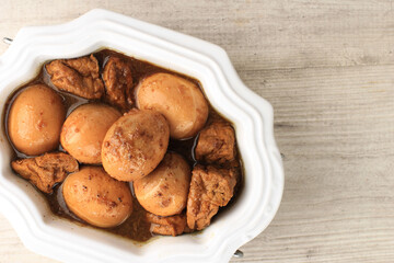 Top View Semur Tahu Telor is Boiled Eggs and Tofu Cooked with Soy Sauce for Family Menu on White Table with Copy Space for Text. Indonesian Popular Food