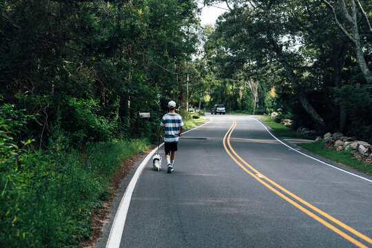 Man walking with Cavapoo dog on road