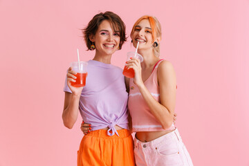 White lesbian couple laughing and drinking soda while hugging