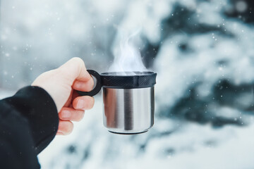 zimowa gorąca herbata w termokubku, gorąca kawa w podróży zimą