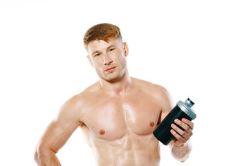 Fototapeta na wymiar a man an athlete with a pumped-up body drinks from a bottle