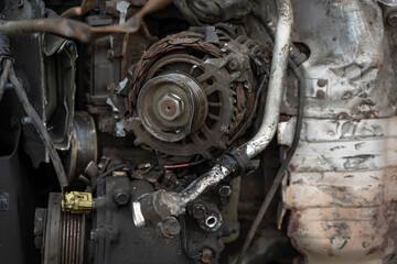 broken car generator. the old generator is on the engine of the car
