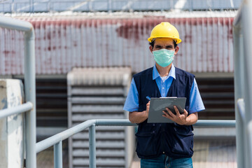 Fototapeta premium Worker with clipboard at factory building background