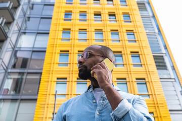 Man talking on smart phone in front of modern building