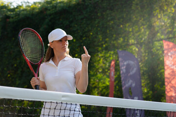 a female tennis player shows her middle finger an indecent rude gesture to a referee or opponent....