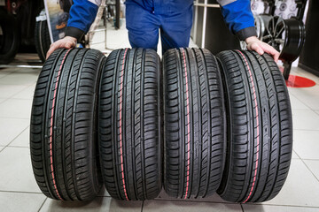 four new tires set of wheels demonstrates a new purchase by the seller, a wide gesture with his...