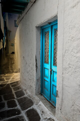 Blue double door in a dark alley on Mykonos Island, Greece.