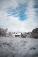 old house covered in snow in a field