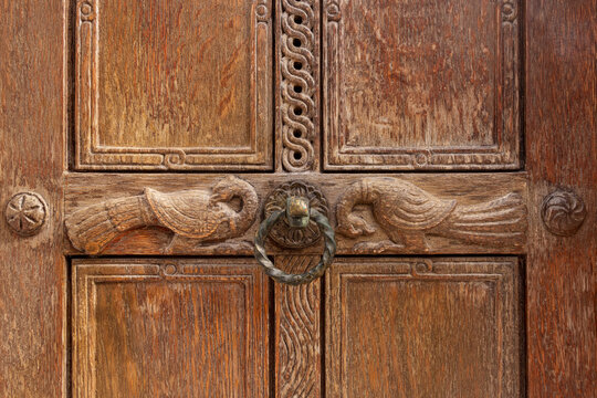 Close up fragment of old wood carving and doorknob. Door of Church of the Holy Apostles. Agora, Athens, Greece