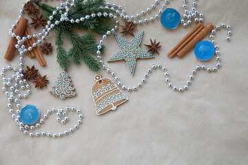 Blue gingerbread composition. Christmas, New year card with fur tree branch, gingerbread, cinnamon, anise on craft paper background. Place for text, top view
