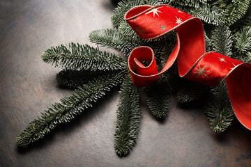 Fra poco è Natale. Decorazione con rami di pino e nastri rossi e oro