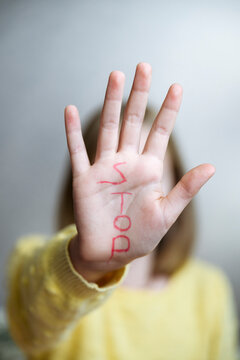 Girl showing stop sign with text on palm