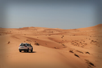 Fototapeta na wymiar one car in the hot Sahara desert in the morning with no people