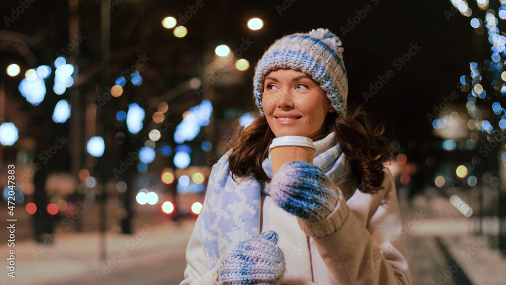 Sticker winter holidays, christmas and people concept - happy smiling young woman drinking takeaway coffee on city street at night