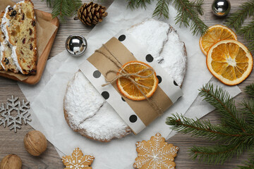 Decorated traditional Christmas Stollen on wooden table, flat lay