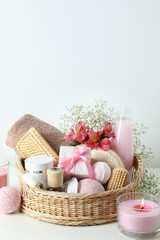 Concept of gift with basket of cosmetics on white table