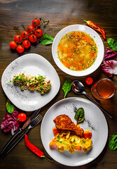 three-course set on a table. Tasty lunch set made of three meals, such as soup, salad and chicken with vegetables