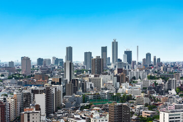 tokyo, japan - may 03 2021: Bird's eye view of a cityscape of the skyscrapers of Ikebukuro district along the horizon line with the landmark of Sunshine 60 building below blue sky.
