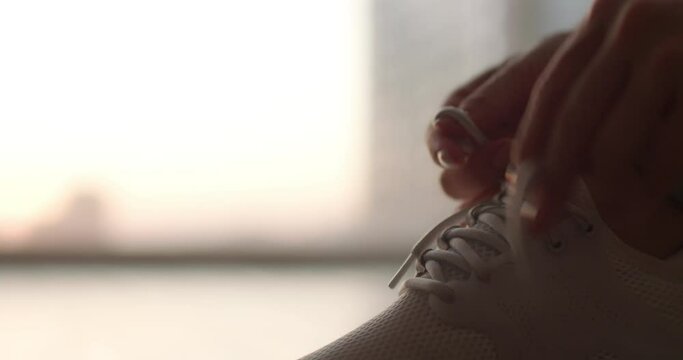 Young woman tying her shoelaces before running,4K