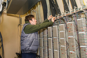 The technician is laying communication lines by conducting internet telephony. servicing the...