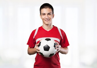 Professional football soccer player standing with ball