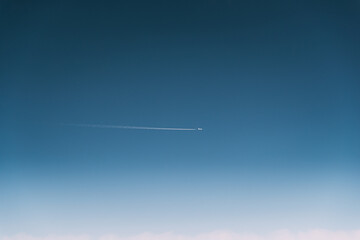 Contrail In Blue Sky. Plane In Sunny Sky. Aircraft In Sky With Plane Trail. View From High Height Flight Of Plane. Travel And Transportation Concept