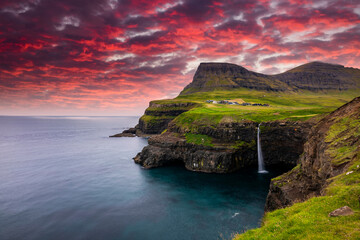 Sunset view of Mulafossur Waterfall and Gasadalur village. Vagar, Faroe Islands.