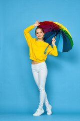 woman with multicolored umbrella in yellow sweater posing rainbow colors