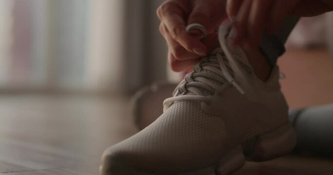 Young woman tying her shoelaces before running,4K