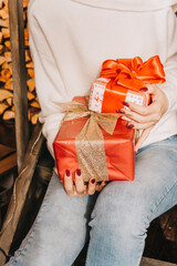 Women's hands give a handmade gift wrapped in paper with a black ribbon.